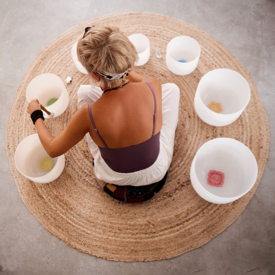 Narelle surrounded by chakra crystal singing bowls, seen from above